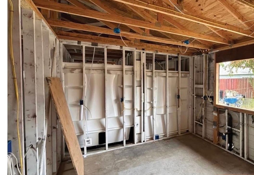 Interior of a single-family house rebuilt to new framing, with electrical rough-in and shower surrounds set